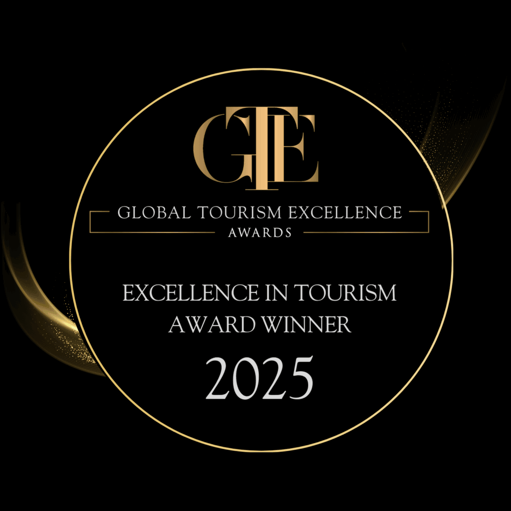 Global Tourism Excellence Award 2025 badge in black with gold text and outline, awarded to Queenstown Wine Trail based solely on guest reviews, recognizing outstanding luxury wine and food tours in Central Otago, New Zealand, with no commercial or political influence.
