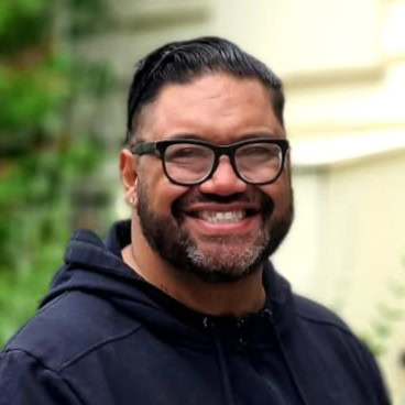 Teaukura Moetaua, WSET 2 qualified wine guide for Queenstown Wine Trail, smiling in a headshot at Kinross Winery in Central Otago, showcasing our expert, friendly guides for our wine and food tours.