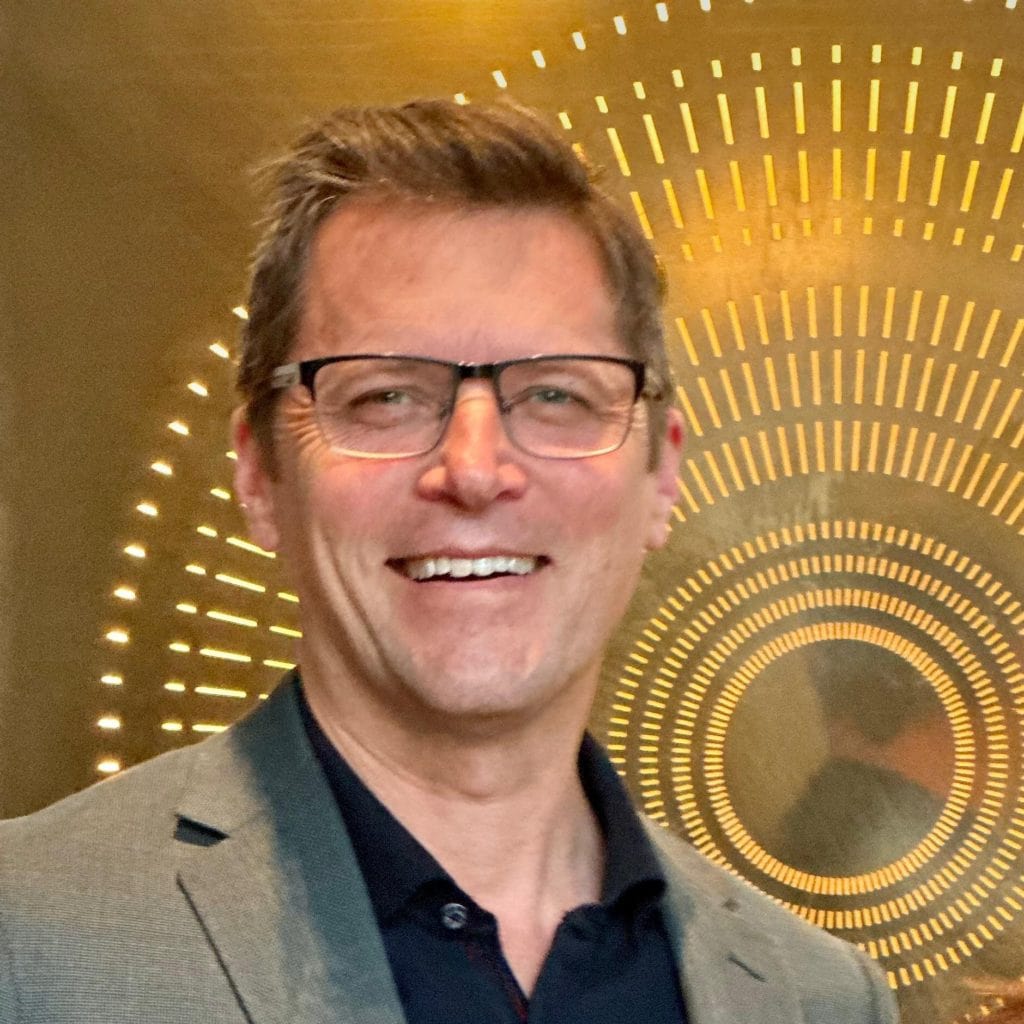 Andrew Bisset, owner of Queenstown Wine Trail, at the opening of Cloudy Bay’s new tasting room in Central Otago, standing against Ed Cruickshank’s newly released artwork titled “Hope,” highlighting the connection between luxury wine experiences and iconic New Zealand art and artists.
